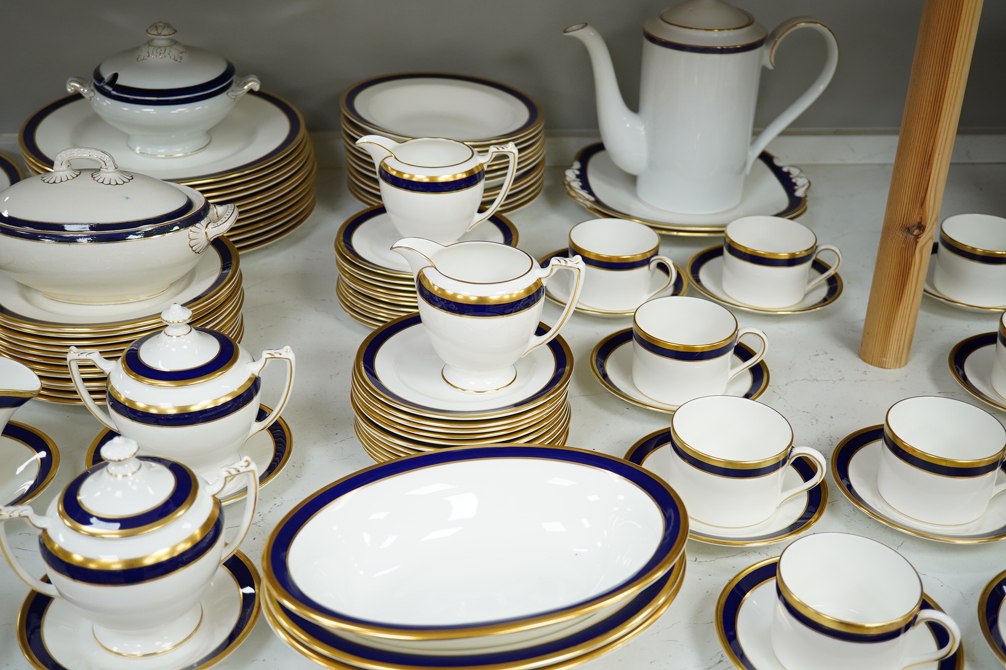 A large part Coalport ‘Rutland’, gilt and blue banded dinner and coffee service, coffee pot and cover 24cm high. Condition - the dinner service is for twelve place settings, the coffee set ten place settings. Condition -